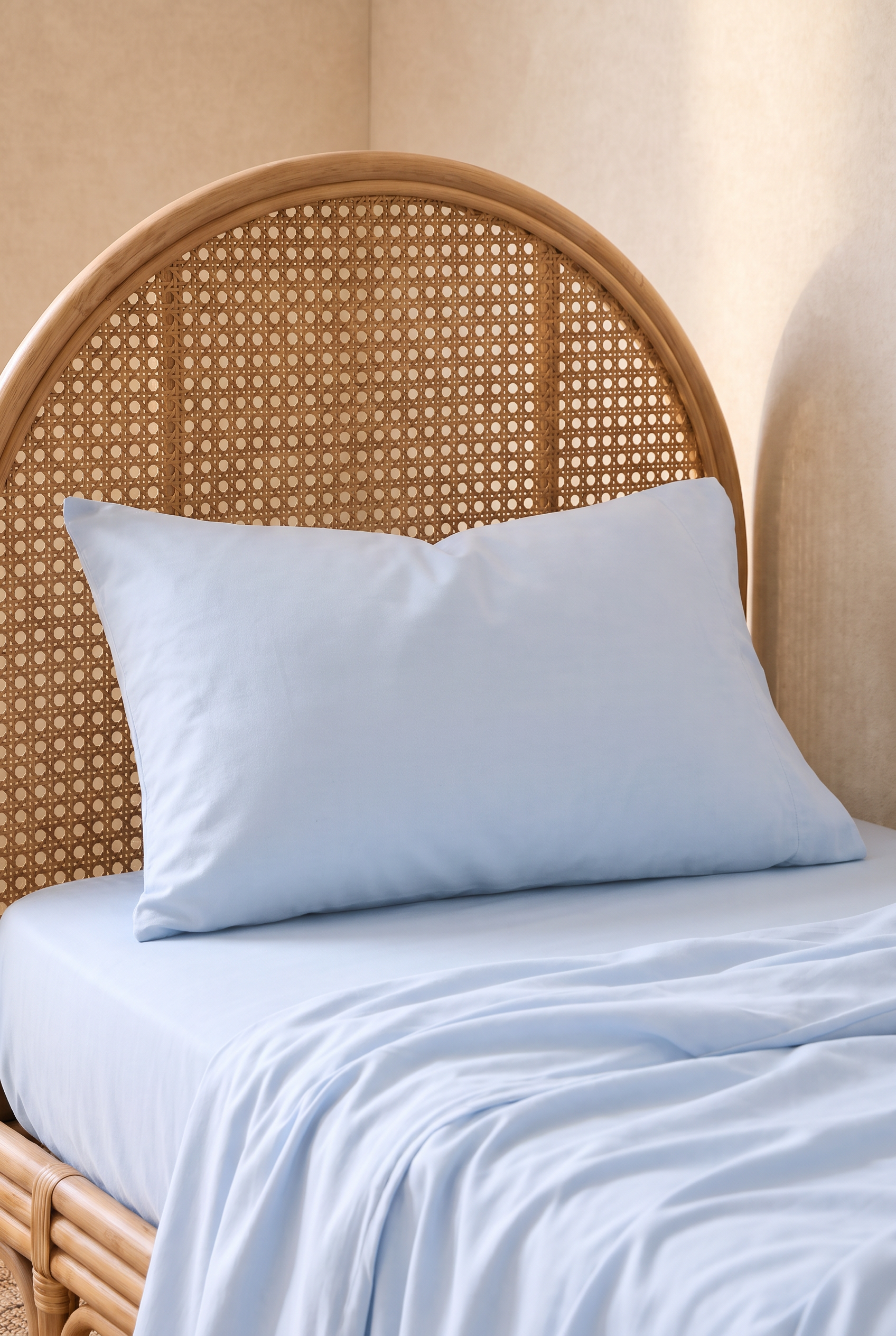 Light blue organic cotton kids bedding set including a pillowcase and fitted sheet on a single bed