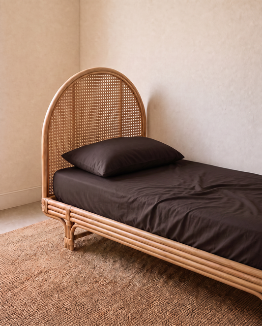 a kids single bed with dark brown sheet set