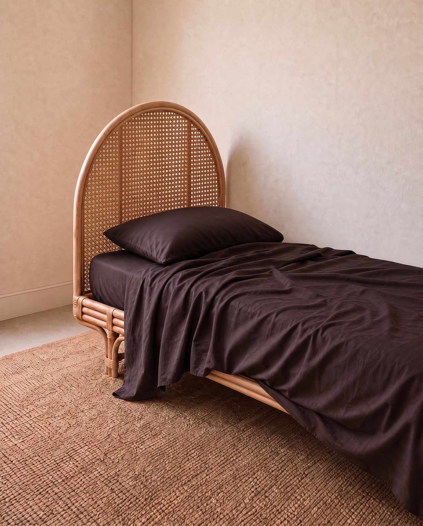 A single bed in dark brown bedding and a matching pillow in a beautiful kids bedroom