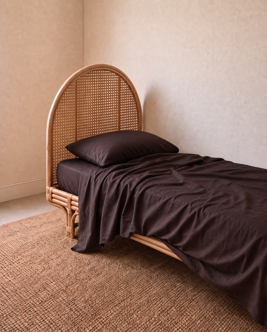 A single bed in dark brown bedding and a matching pillow in a beautiful kids bedroom