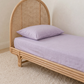 Lavender Organic Cotton Sheet by the cuddle collective styled on a single bed