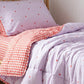A red gingham and lavender reversible quilt for girls 