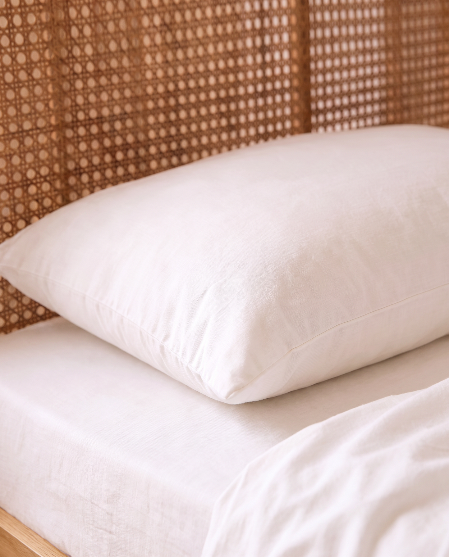 a white organic cotton pillowcase in a natural bedroom