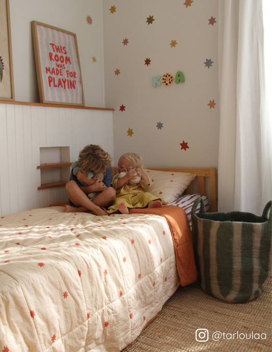 A fun kids bedding set featuring a reversible quilt by the cuddle collective, stripe sheet set and star wall decals