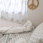 A neutral and coastal kids bed made with organic cotton sheets and organic cotton reversible quilt blanket with wavy stripe print completes this cute coastal kids bedding linen look | The Cuddle Collective