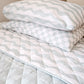 A neutral and coastal kids bed made with organic cotton sheets and organic cotton reversible quilt blanket with wavy stripe print completes this cute coastal kids bedding linen look | The Cuddle Collective