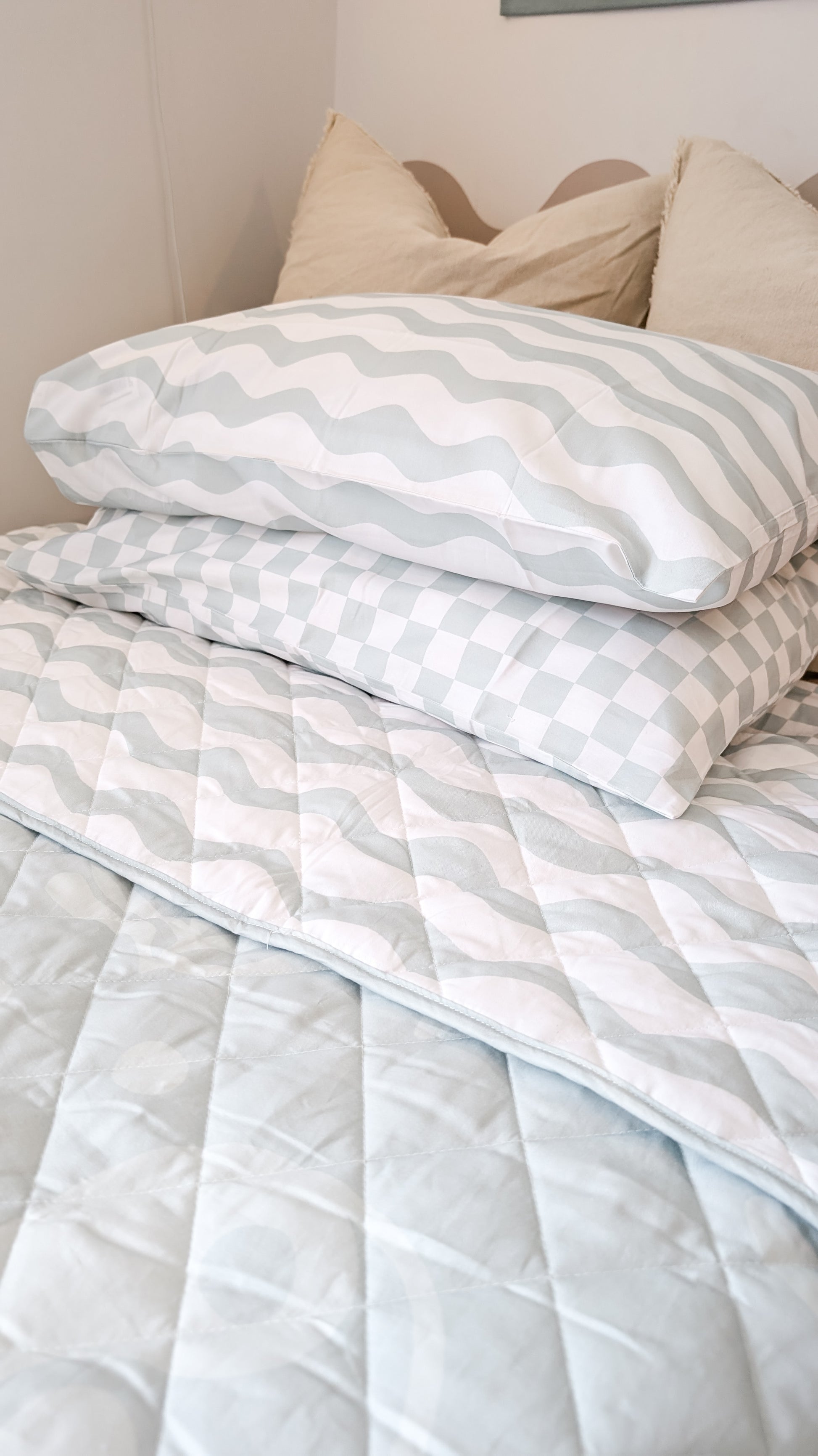 A neutral and coastal kids bed made with organic cotton sheets and organic cotton reversible quilt blanket with wavy stripe print completes this cute coastal kids bedding linen look | The Cuddle Collective