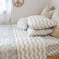 A neutral and coastal kids bed made with organic cotton sheets and organic cotton reversible quilt blanket with wavy stripe print completes this cute coastal kids bedding linen look | The Cuddle Collective
