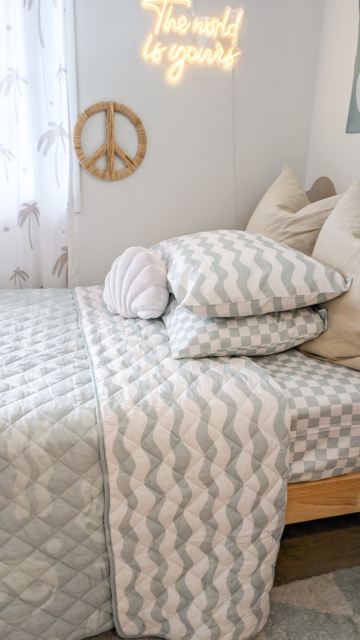 A neutral and coastal kids bed made with organic cotton sheets and organic cotton reversible quilt blanket with wavy stripe print completes this cute coastal kids bedding linen look | The Cuddle Collective