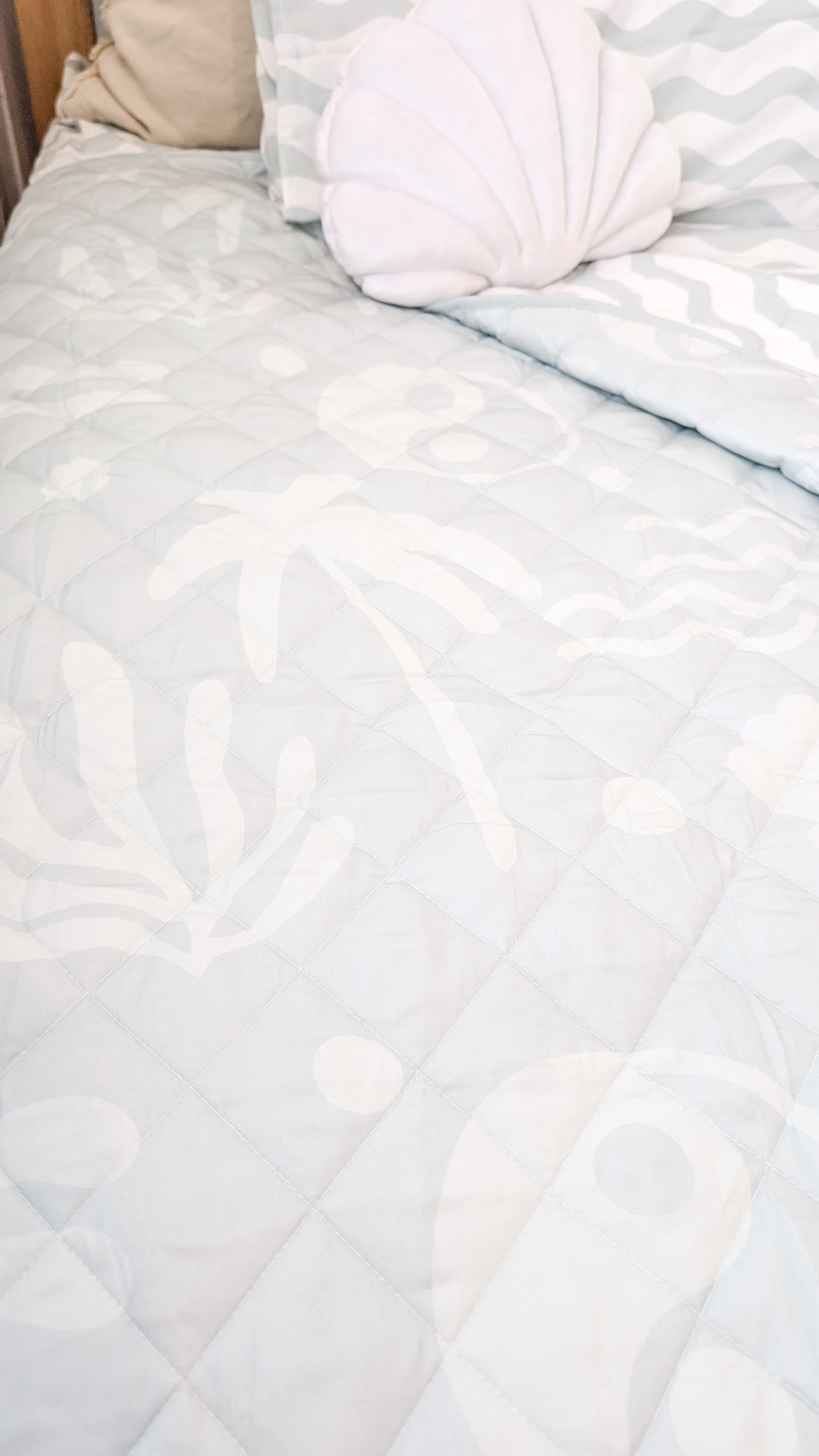 A neutral and coastal kids bed made with organic cotton sheets and organic cotton reversible quilt blanket with wavy stripe print completes this cute coastal kids bedding linen look | The Cuddle Collective
