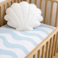 cot sheet with light blue waves on a cot in a nursery