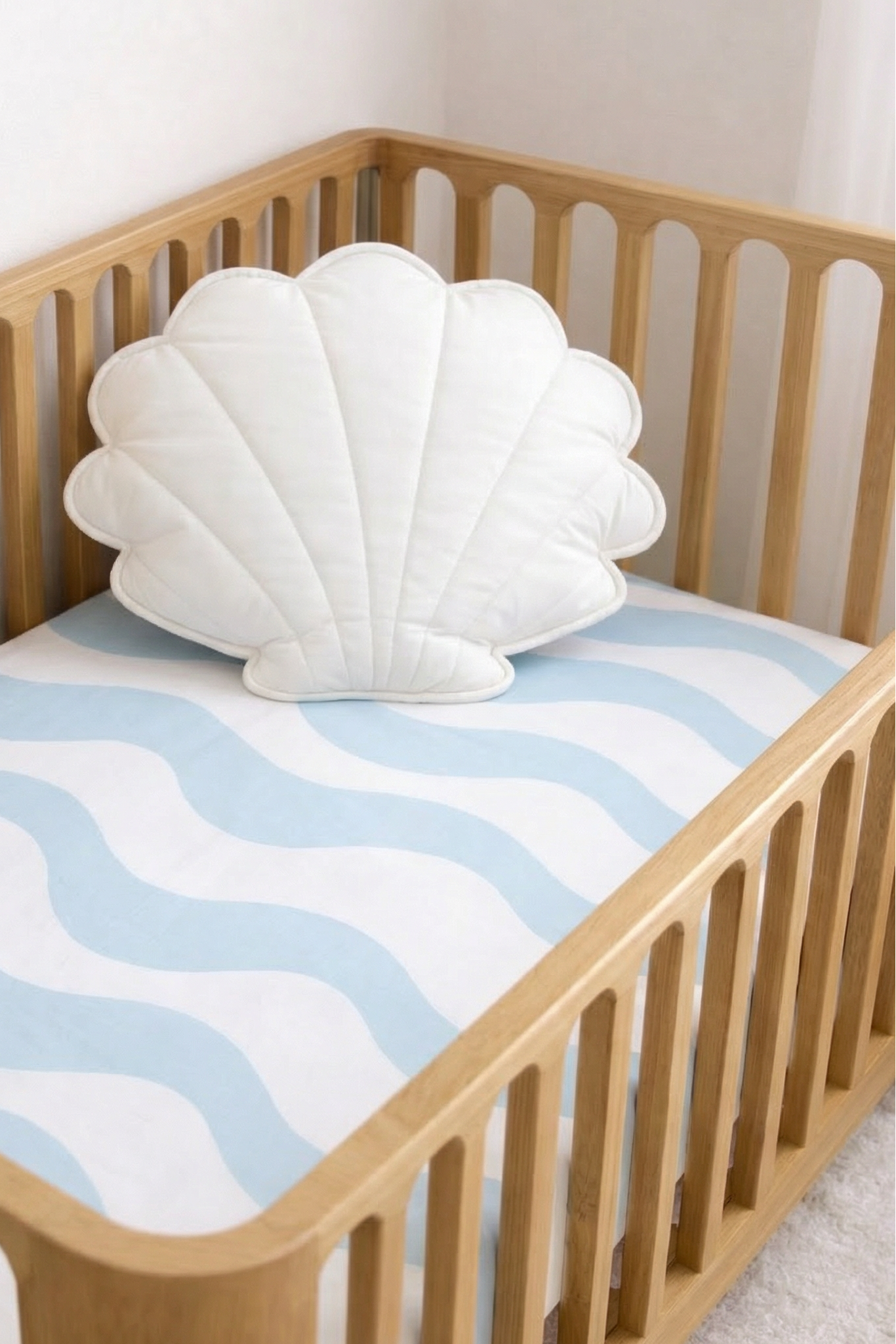 cot sheet with light blue waves on a cot in a nursery