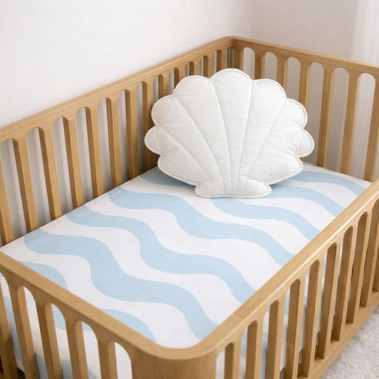 cot sheet with light blue waves on a cot in a nursery