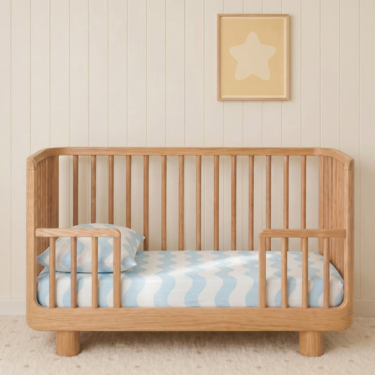 cot sheet on a baby cot in a nursery with blue waves