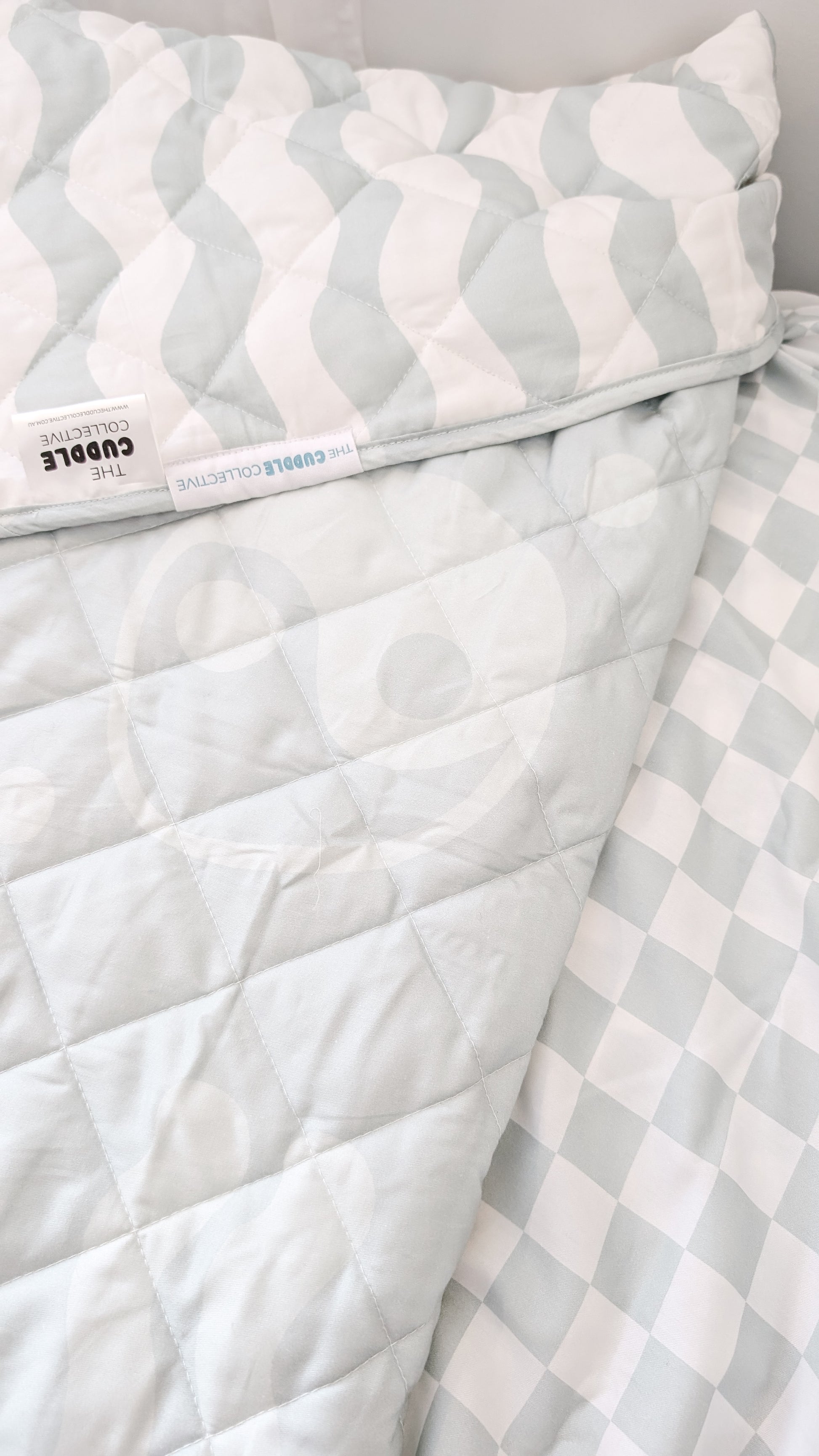 A neutral and coastal kids bed made with organic cotton sheets and organic cotton reversible quilt blanket with wavy stripe print completes this cute coastal kids bedding linen look | The Cuddle Collective