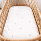 organic cotton sage palm and moon print cot sheets in a cot