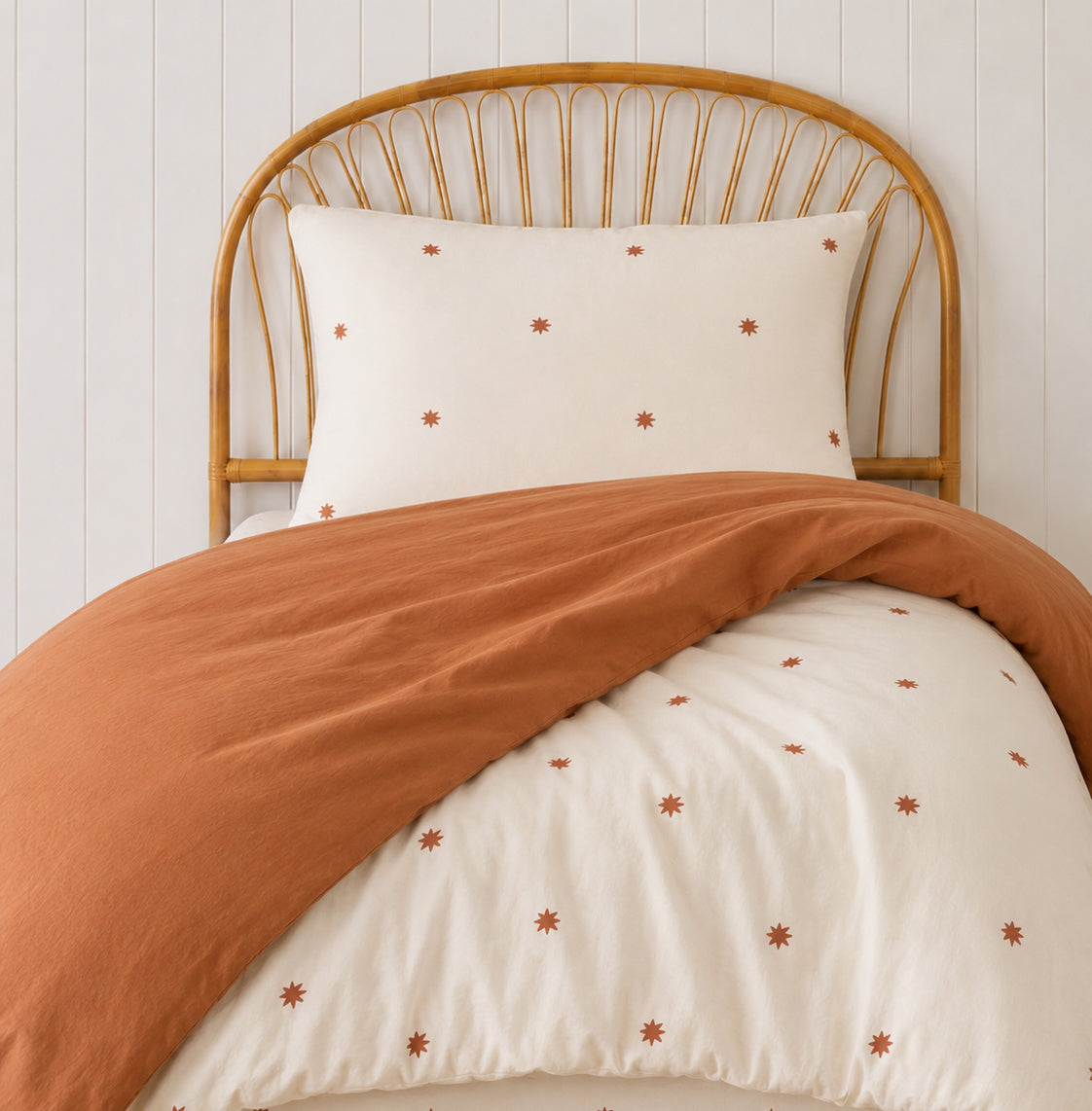 a teracotta and star print quilt cover made with organic cotton, for the cuddle collective. a beautiful kids bedding set